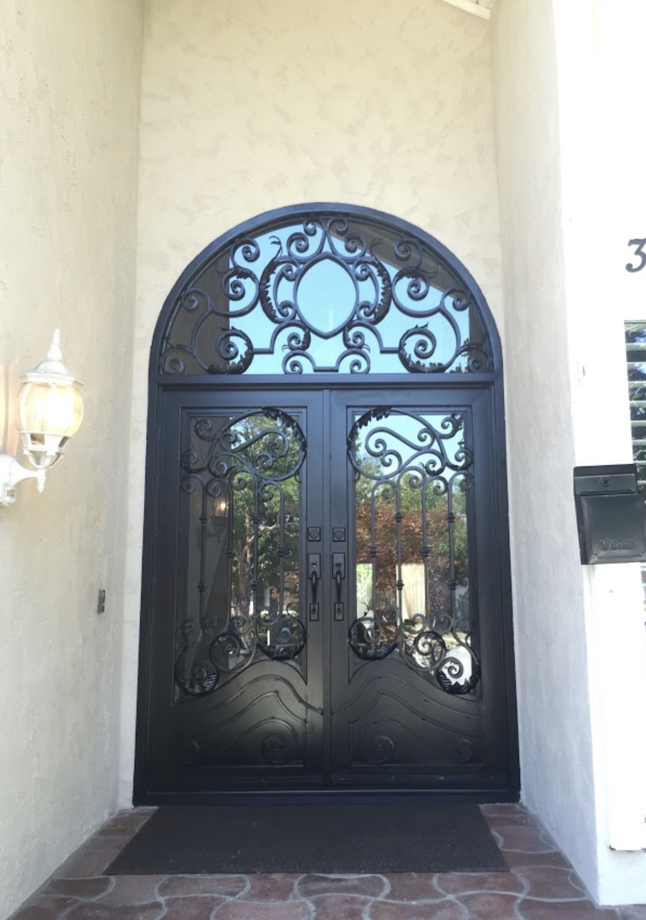 Double Iron Door with Arched Scrollwork Transom