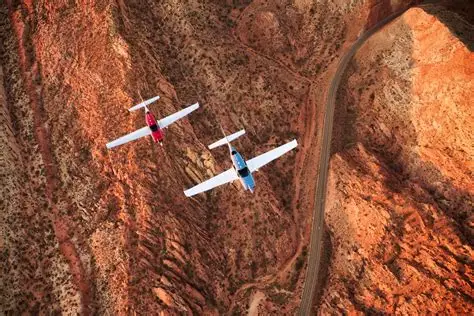 Two Cirrus aircraft flying in formation over an Arizona desert canyon