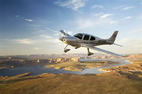 Silver Cirrus aircraft banking over a canyon with a river below