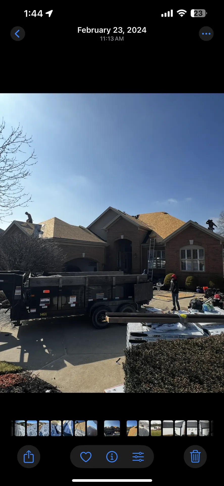 TNT Roofing roof replacement in progress with dump trailer and IKO Dynasty shingle pallets on site