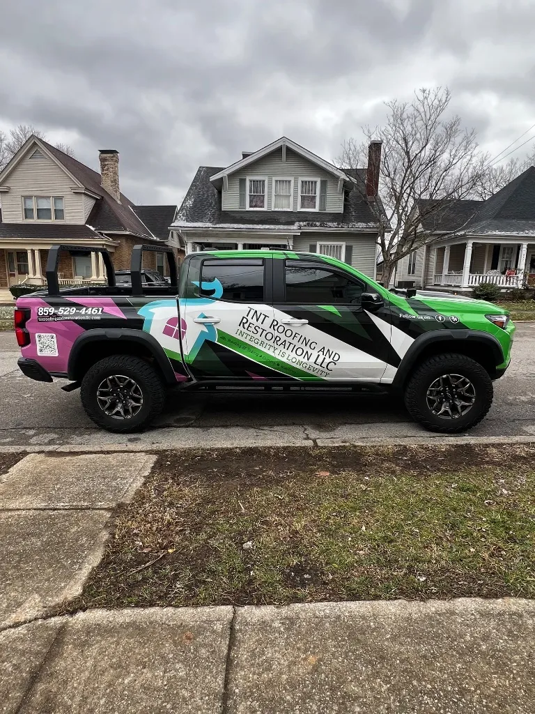 TNT Roofing & Restoration service truck in front of residential home