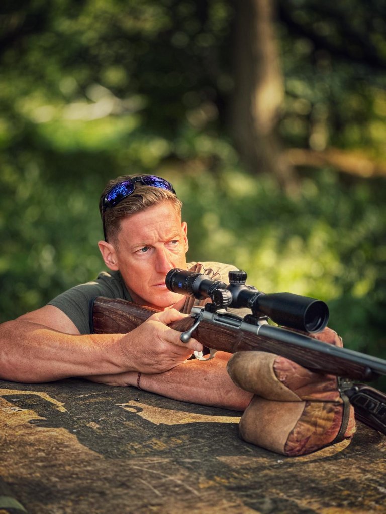 Paul Childerley aiming a scoped rifle