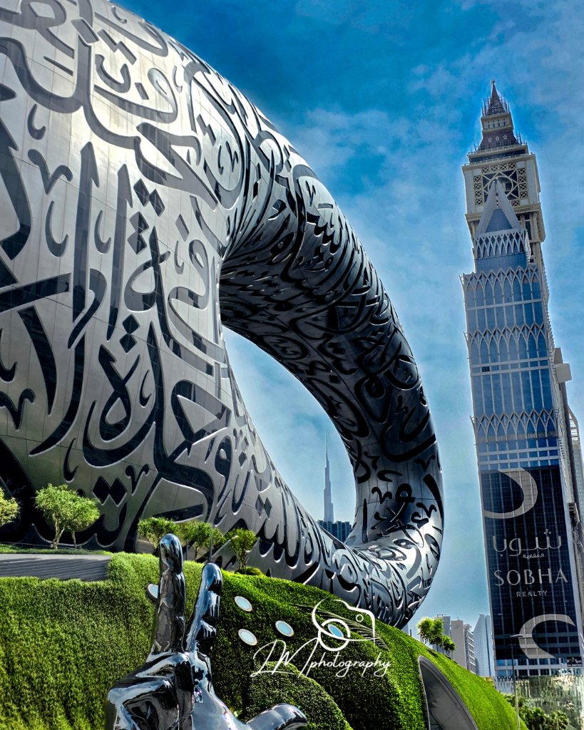 Modern building with Arabic calligraphy and minaret in Dubai skyline