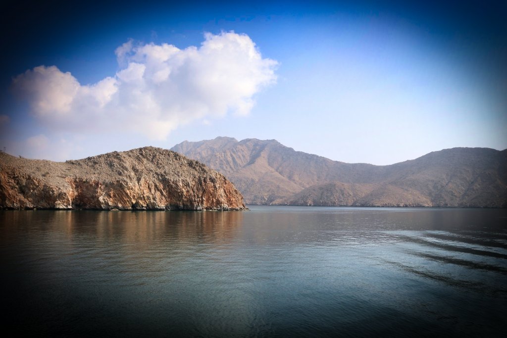 Mountain landscape reflected in calm waters under blue sky