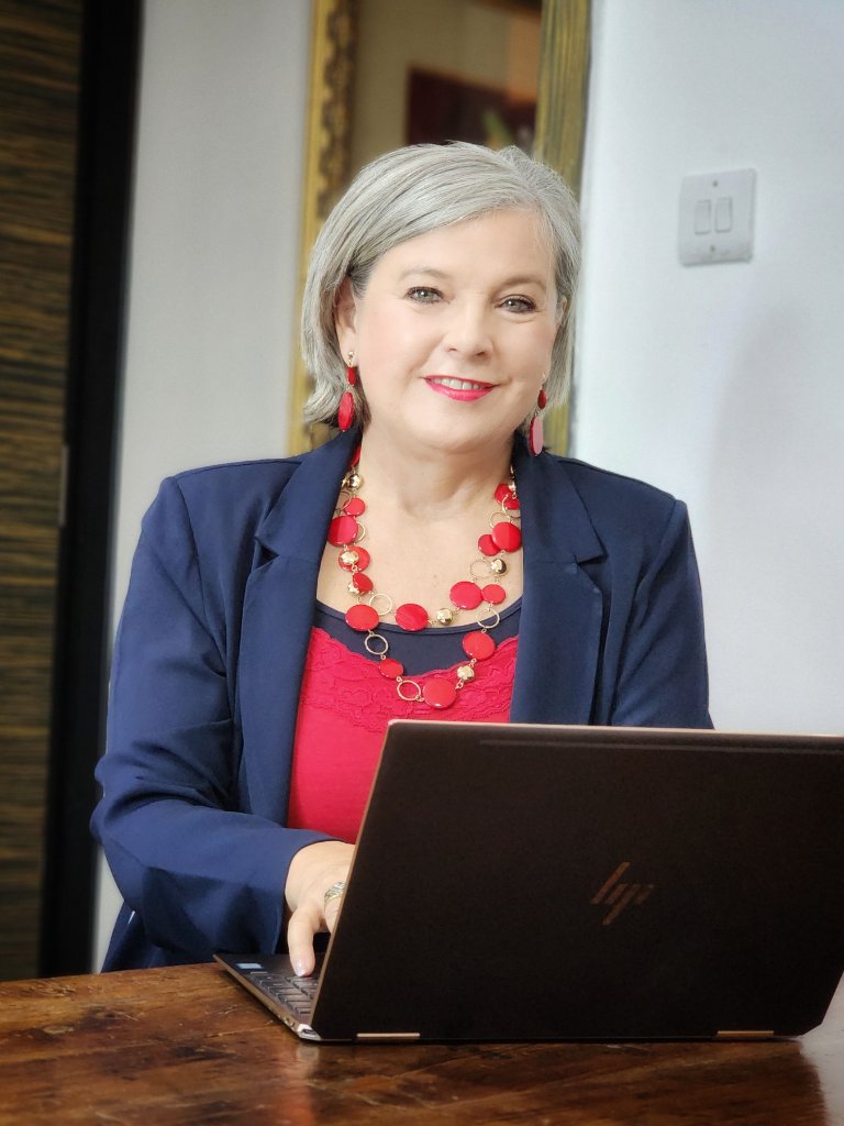Business portrait of woman in navy blazer at laptop