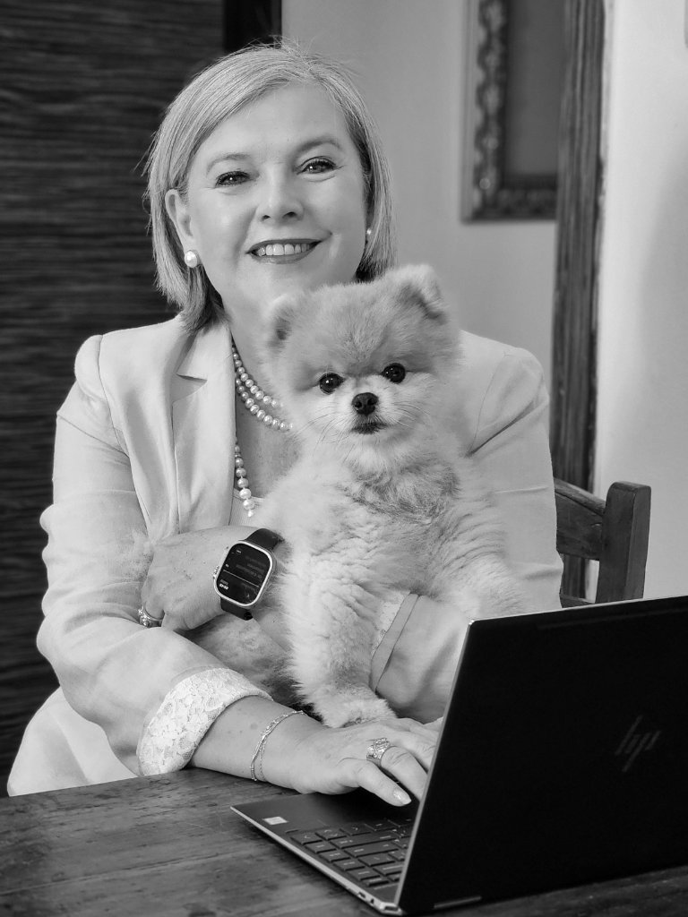 Black and white portrait of woman with Pomeranian at desk