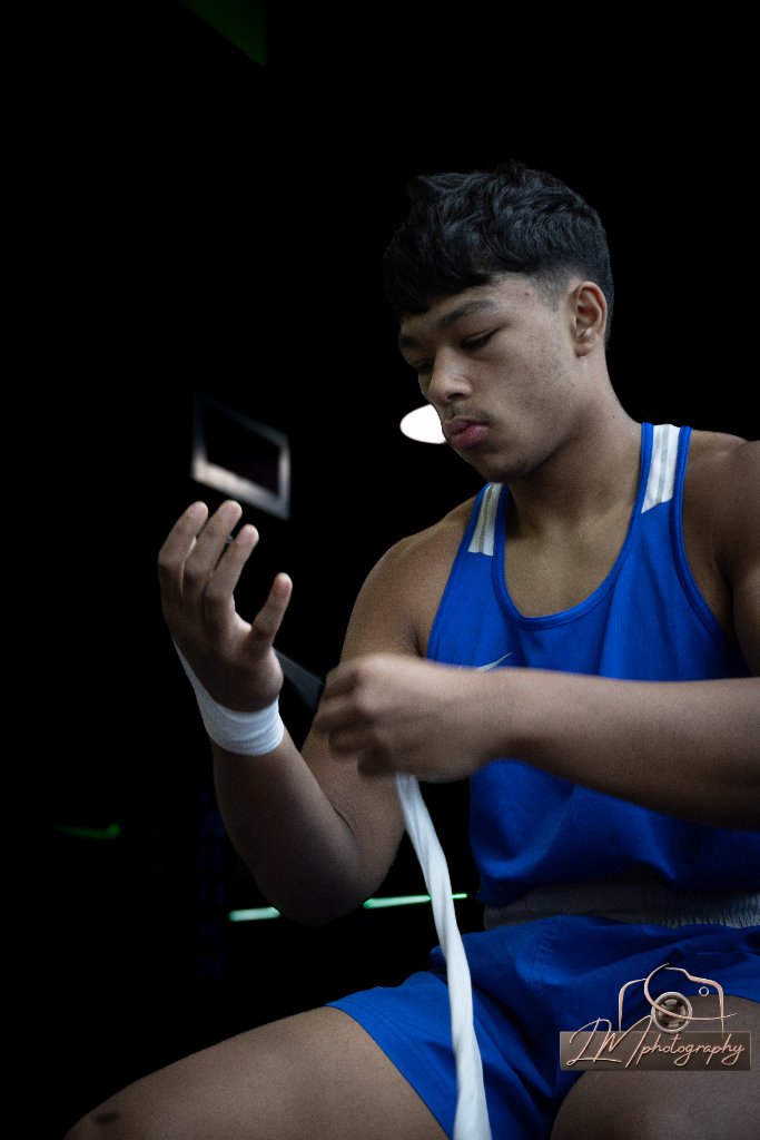 Boxer wrapping his hand with athletic tape before training