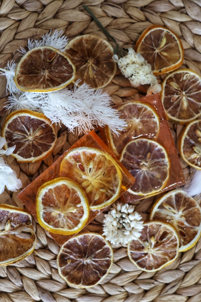 Citrus orange slice soap bars with dried flowers commercial product photography