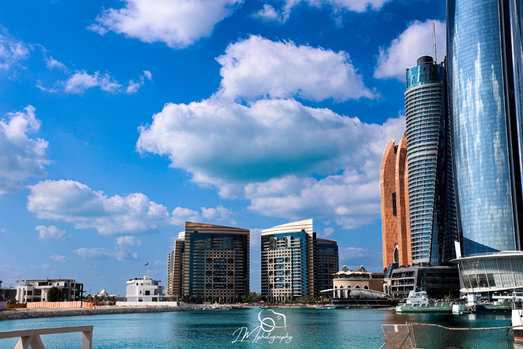Modern buildings and skyscrapers along waterfront with blue sky