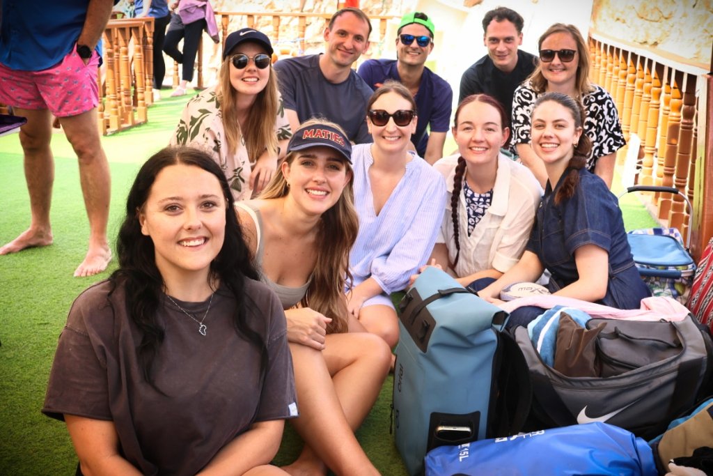 Large group of friends celebrating together at outdoor event, genuine smiles and happy moments