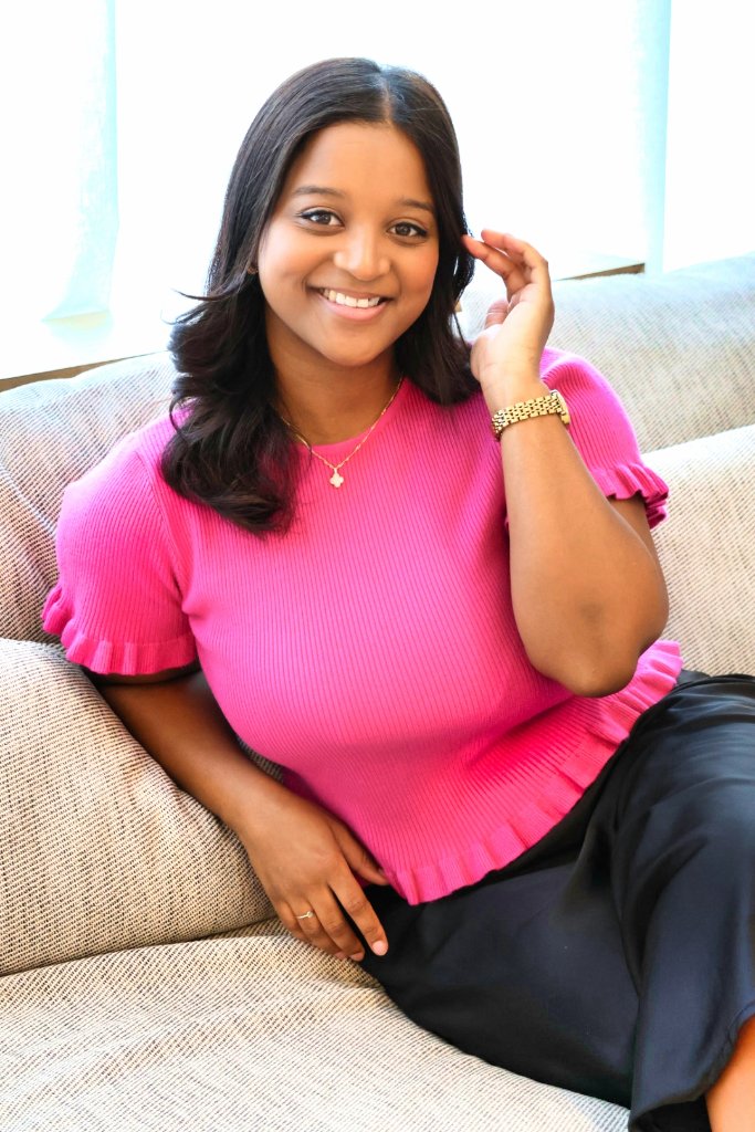 Young woman portrait in bright pink top with natural light, warm and friendly expression