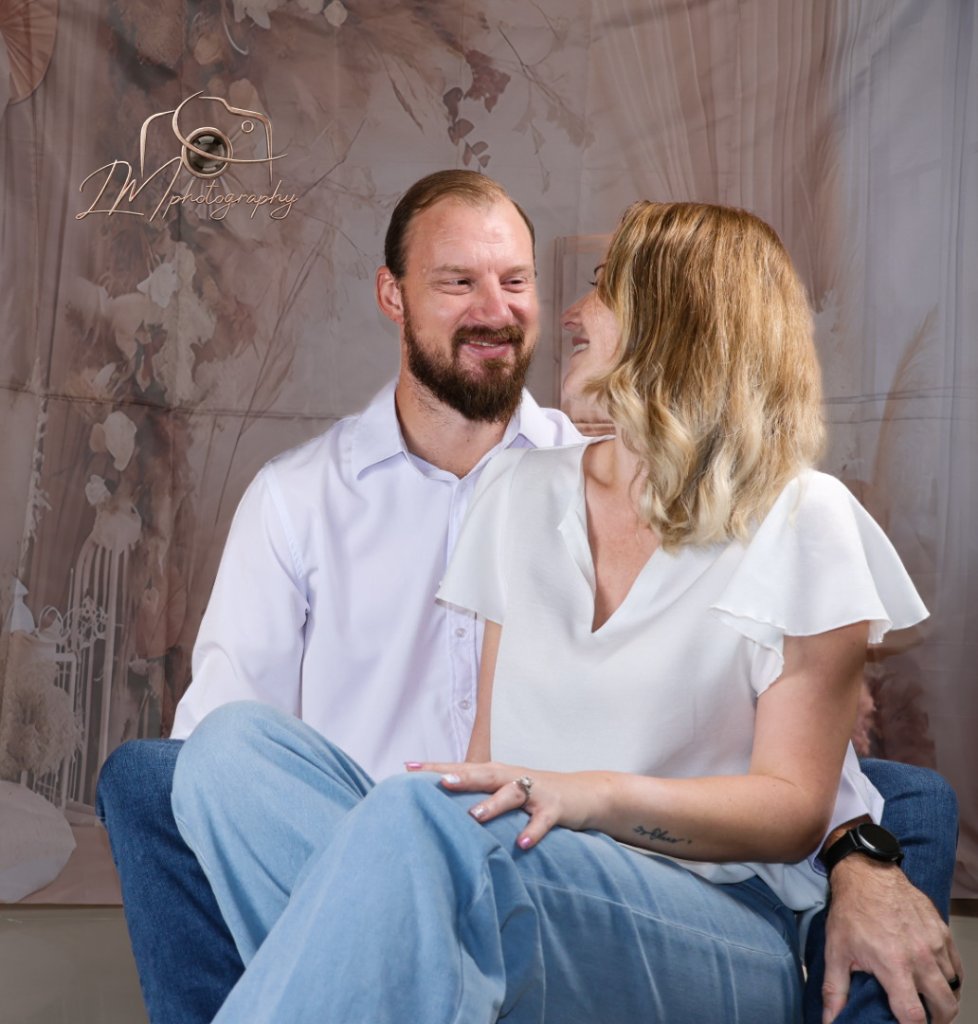 Couple smiling with romantic indoor studio backdrop