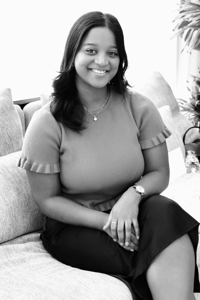 Black and white portrait of young woman in textured top, elegant studio setting with soft lighting