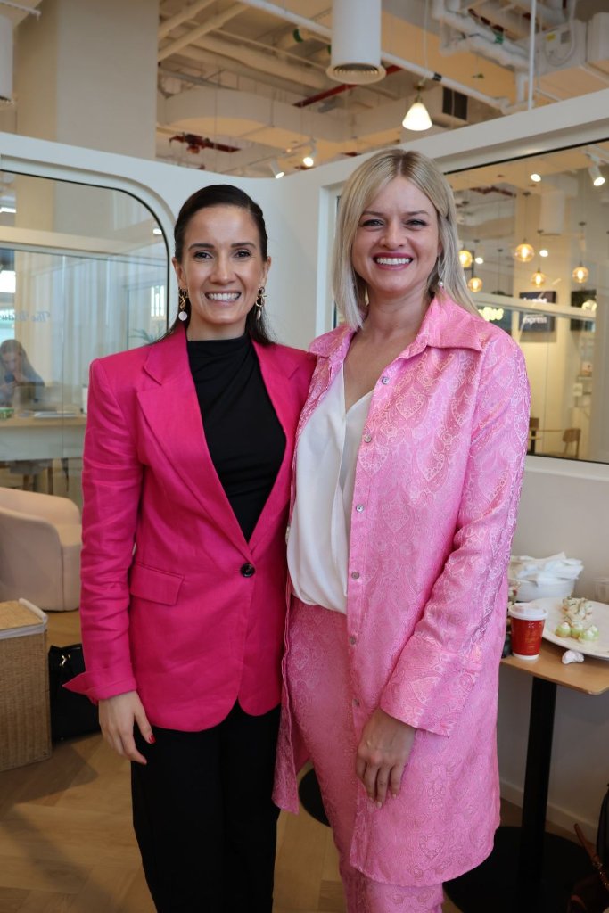 Two women in pink outfits at networking event Dubai