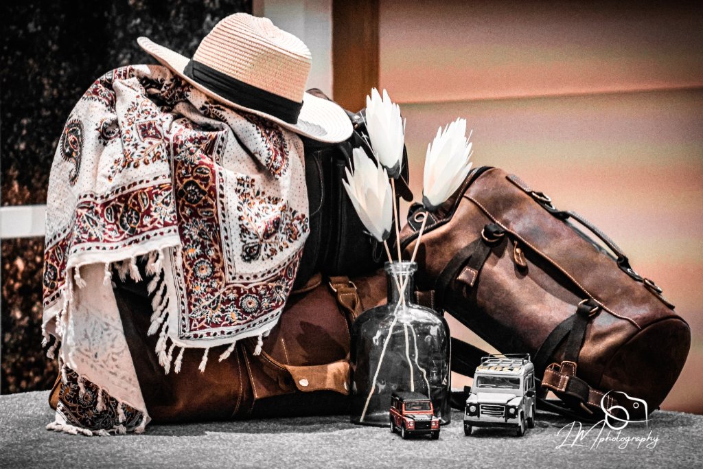 Styled flat lay with hat, scarf, travel accessories and flowers