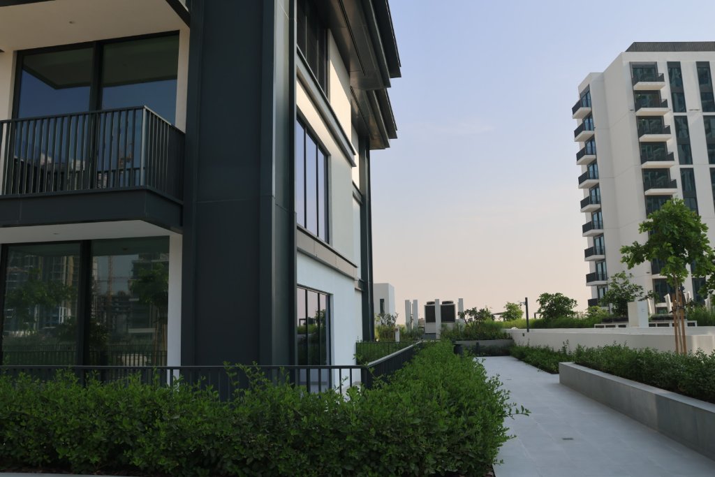 Modern residential pathway between apartment buildings with green landscaping and contemporary design