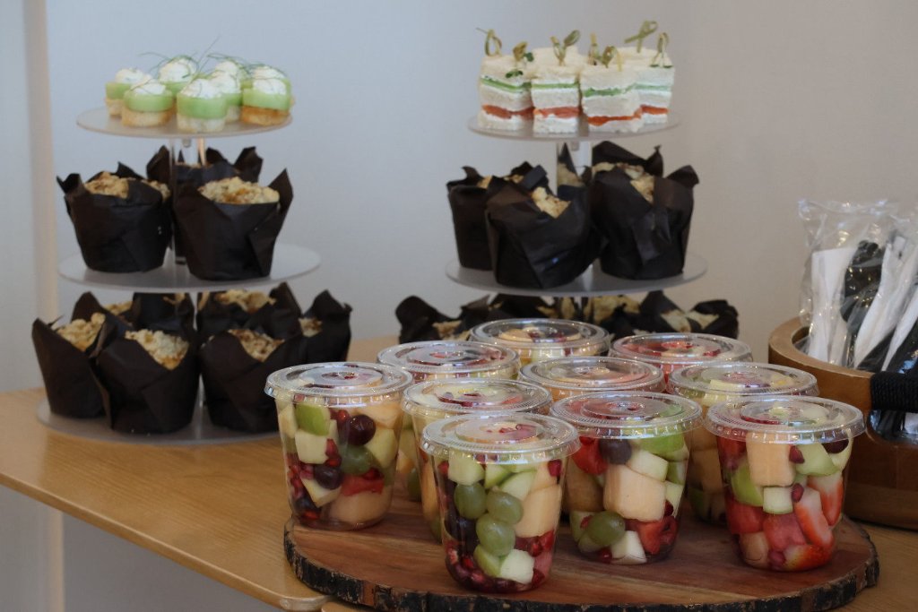 Event catering spread with muffins fruit cups and sandwiches