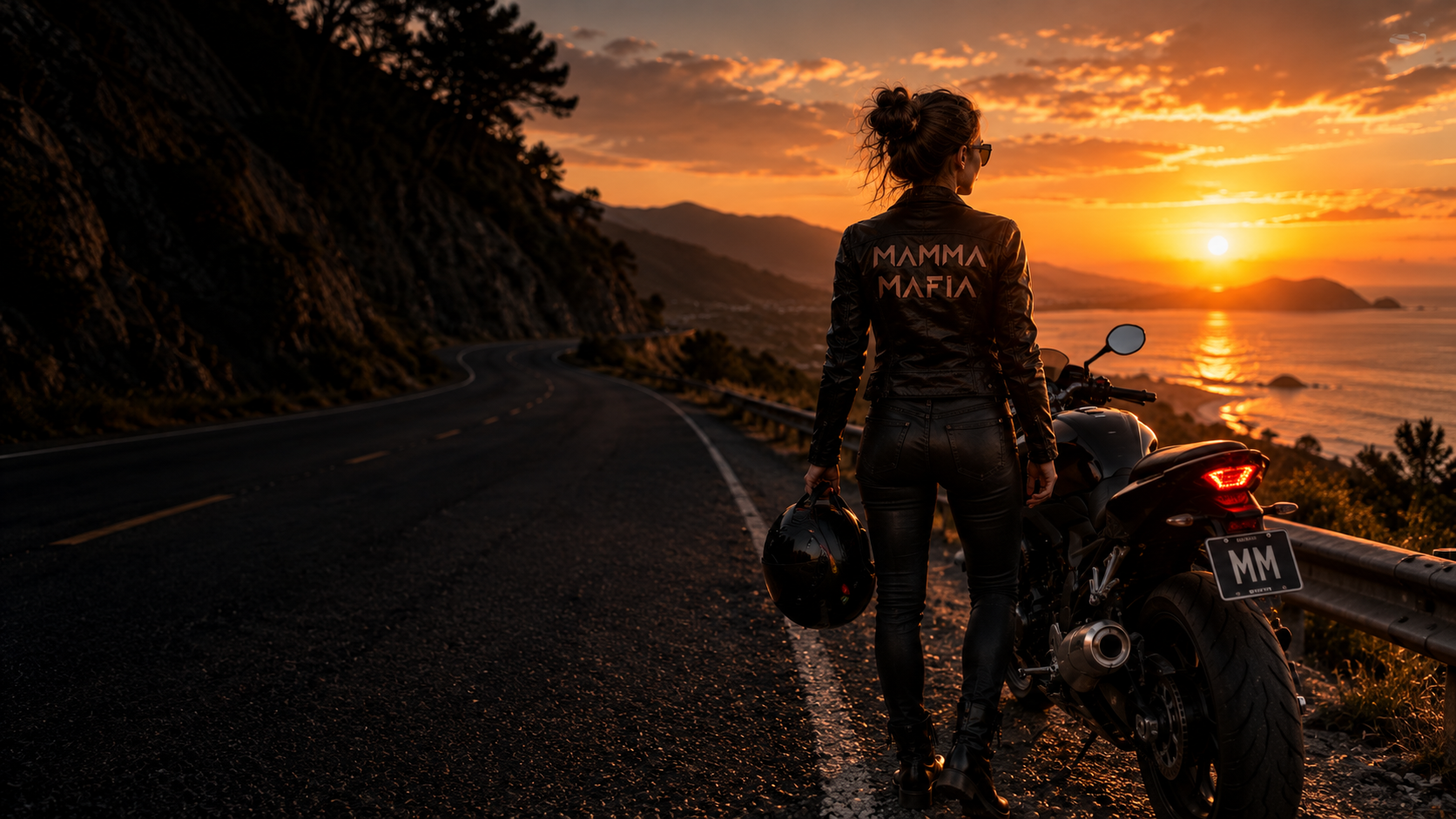 A woman beside her motorcycle on a coastal road at sunset, facing the ocean