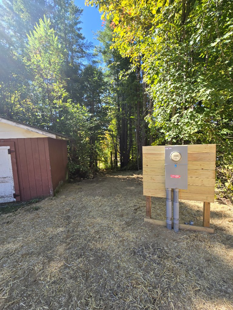 Completed meter base installation — new service panel mounted on treated lumber backing