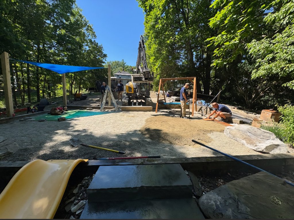 Heavy equipment work in progress — grading, material separation, and feature construction