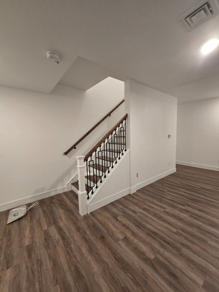 Finished Vermont lower-level renovation with new staircase and railing by Dark Horse Construction