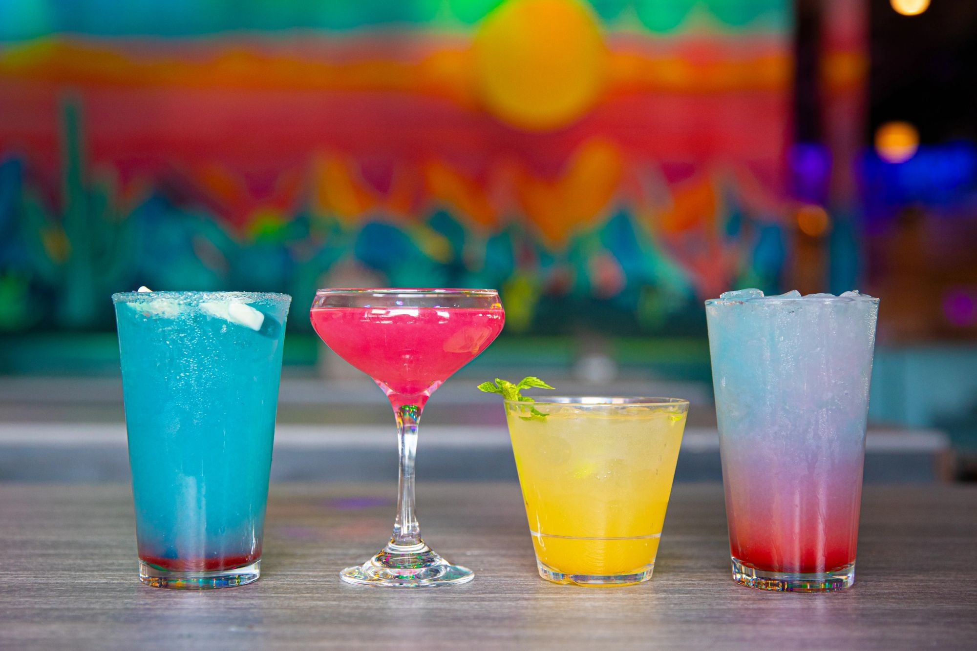 Four colorful cocktails on the bar