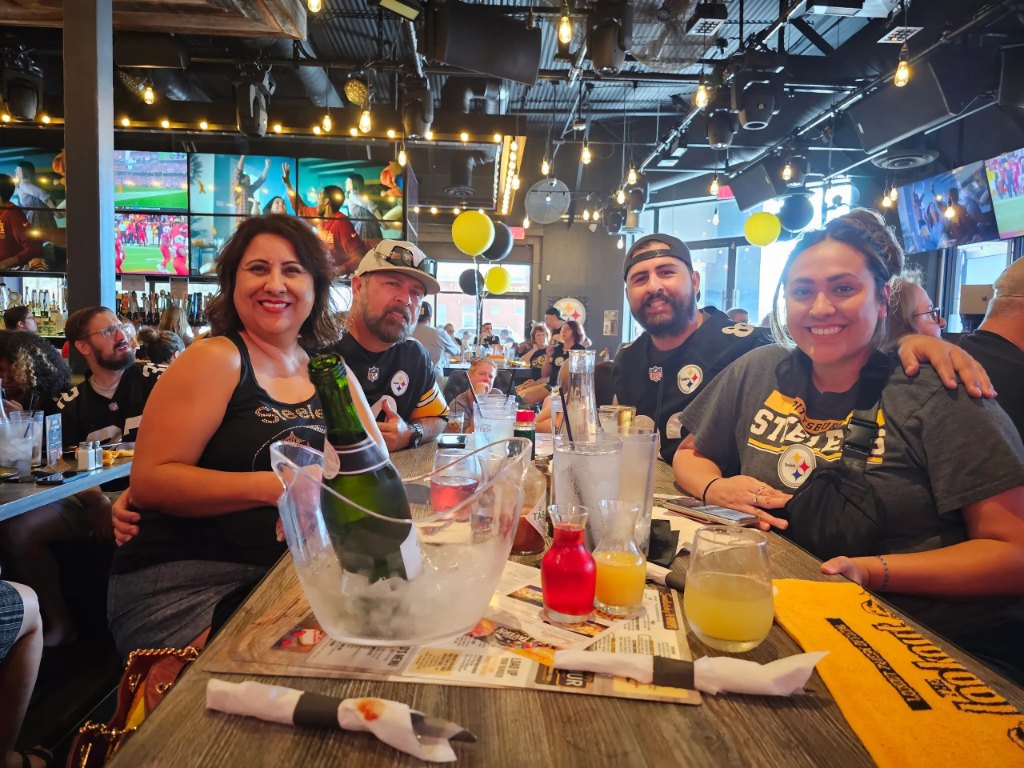Steelers fans in black and gold at a table on game day
