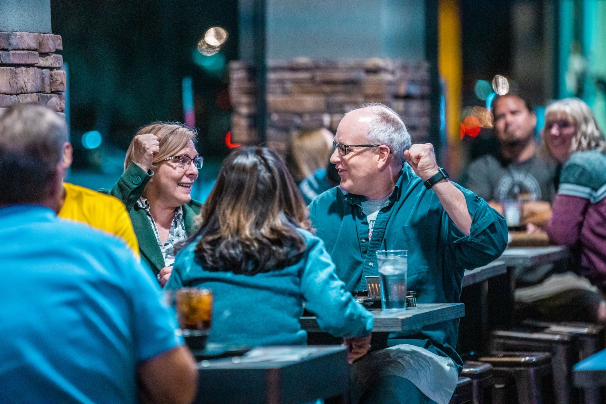 A trivia team cheering at their table