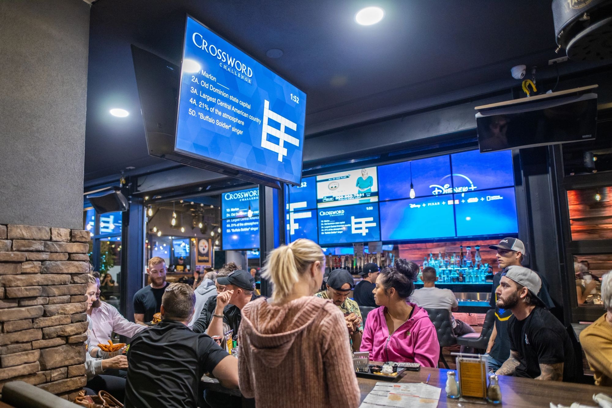 A game night crowd under the TV walls