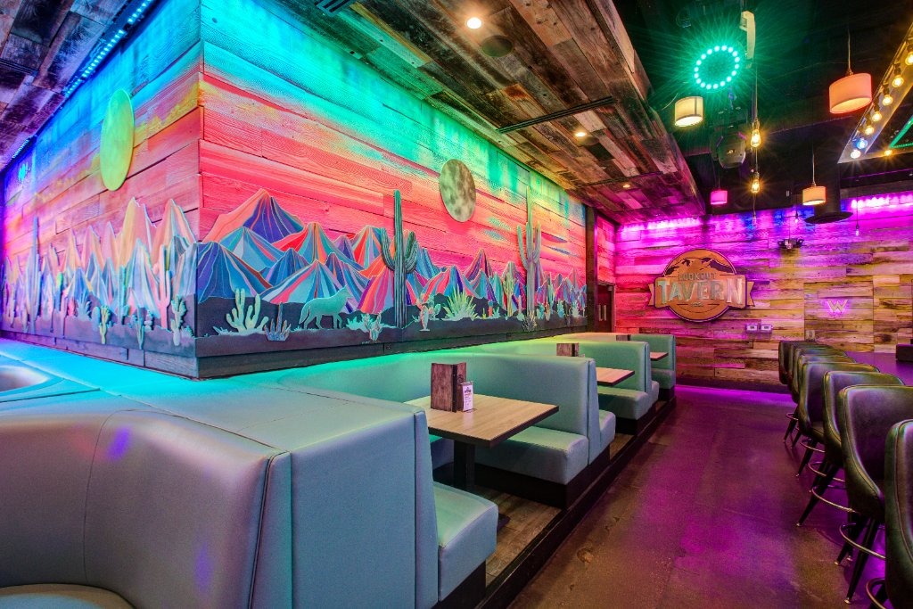 Teal booths under the painted desert mural