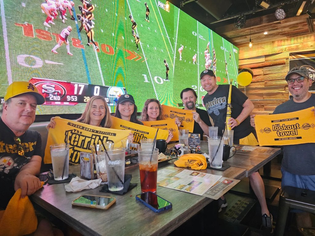 Steelers fans with Lookout towels in front of the LED wall at Lookout Tavern
