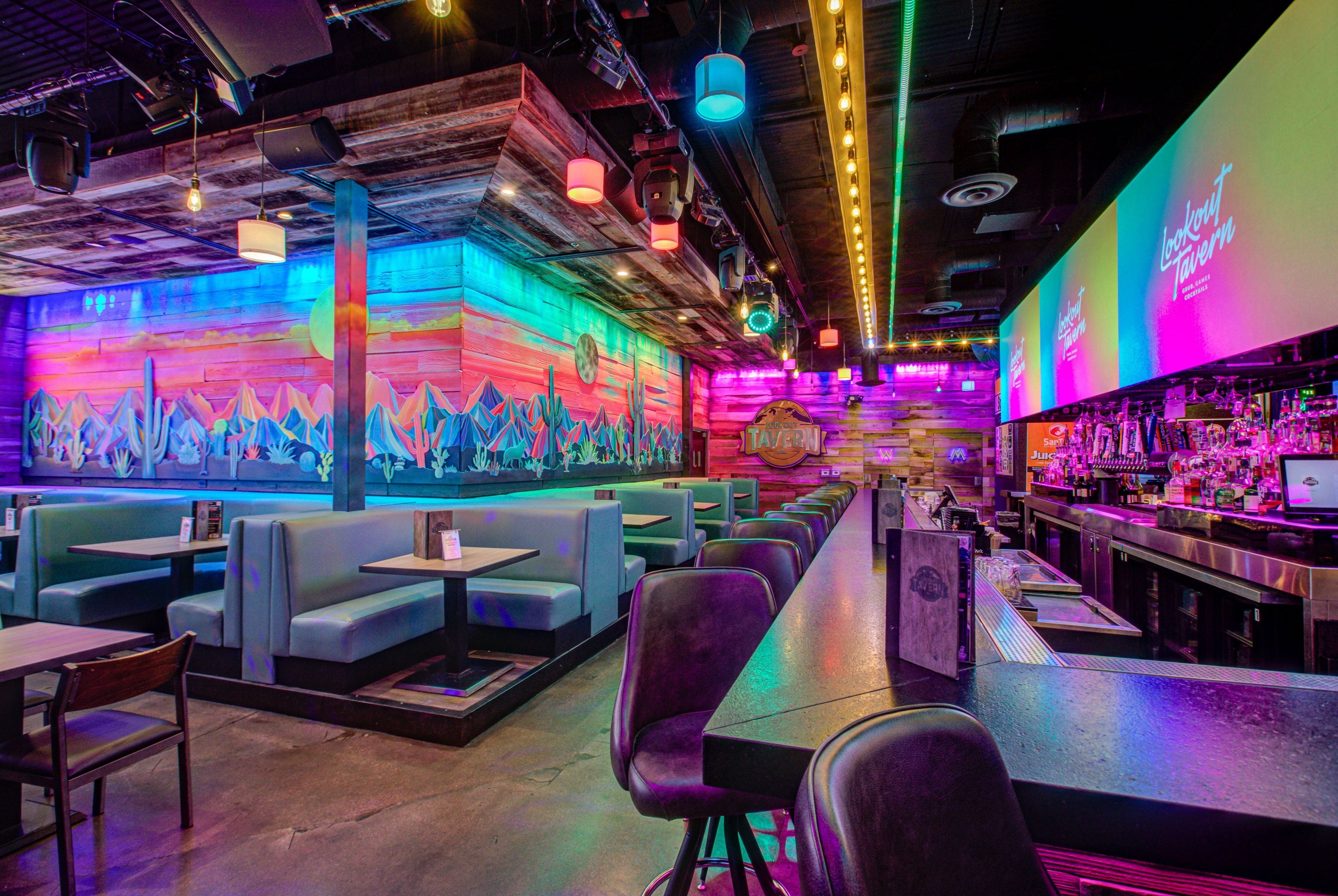 Booths, tables and the LED wall along the desert mural