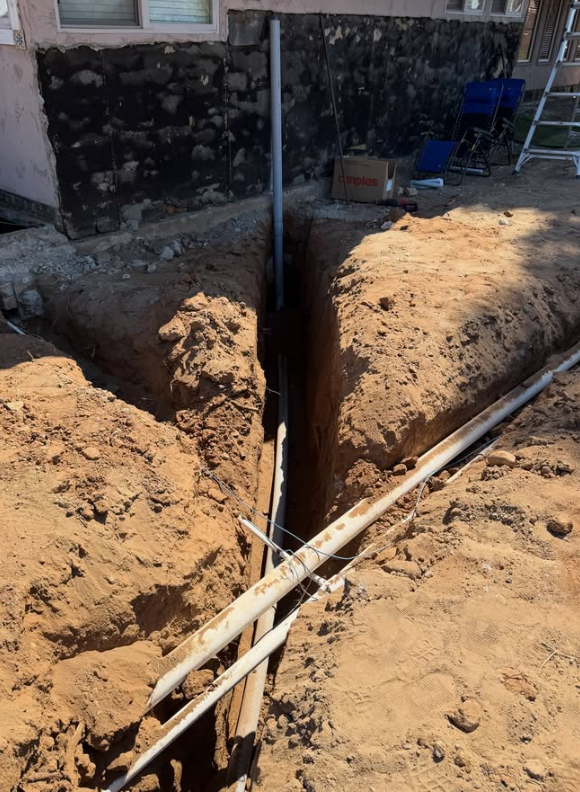 Underground trenching connecting conduit installation to the home foundation in Eucalyptus Hills, CA