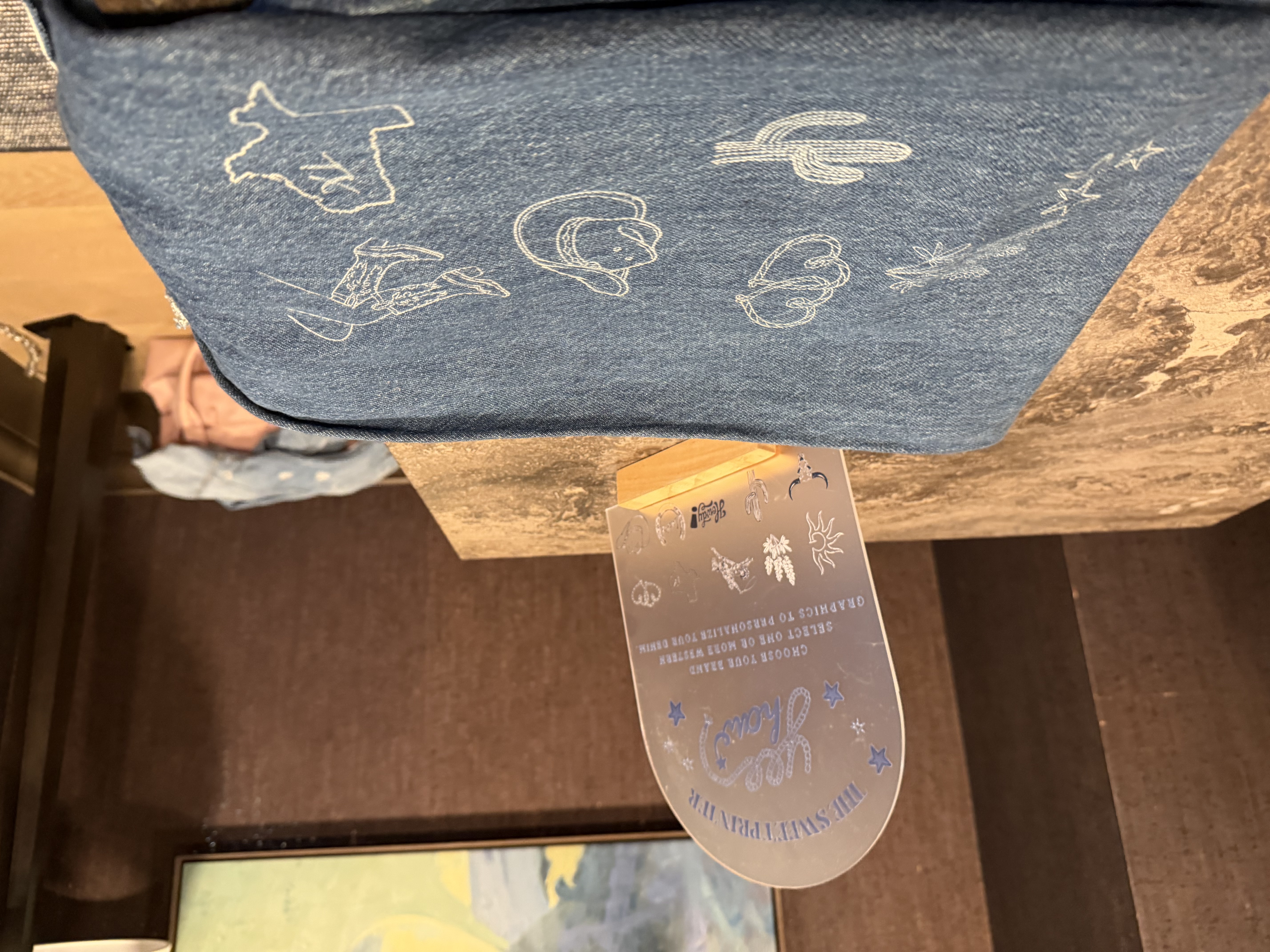 Western-themed embroidered denim designs and a 'Choose Your Brand' customization sign used across multi-location retail activations