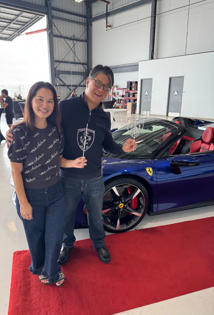 Couple with Ferrari logo lollipops at luxury event