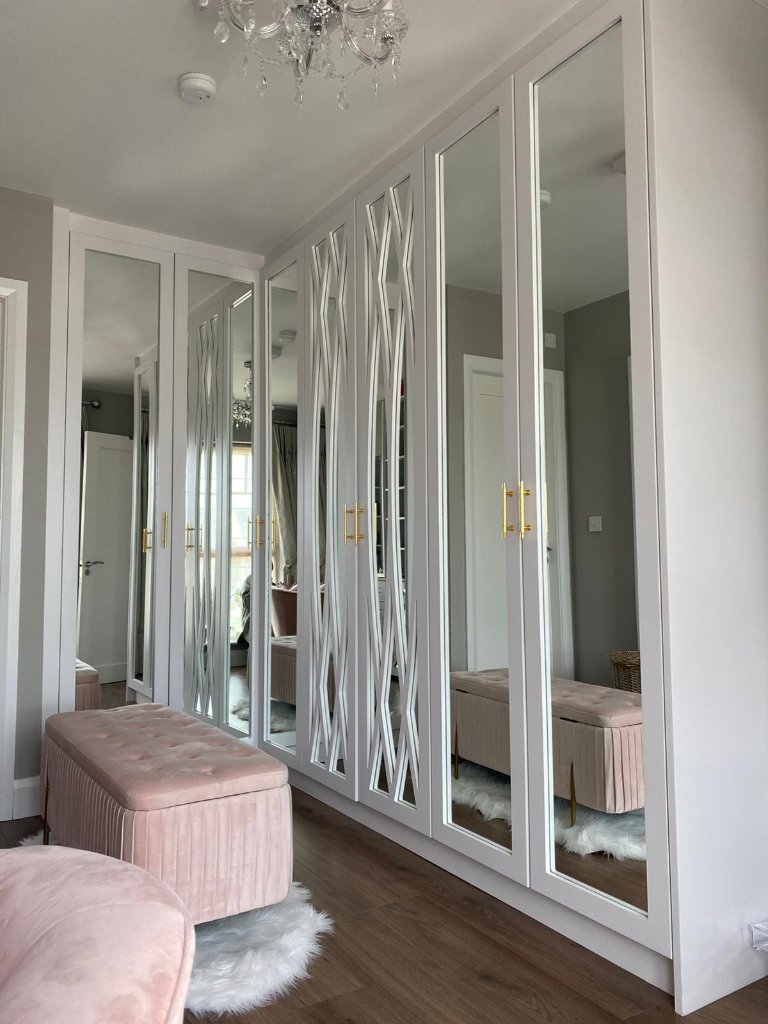 White fitted wardrobes with mirror doors and geometric detail by HEFF