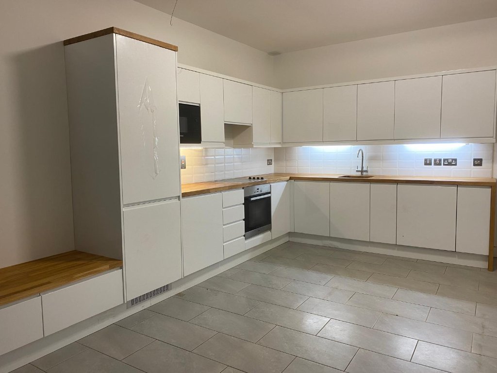 Modern handleless white kitchen with oak worktops by HEFF