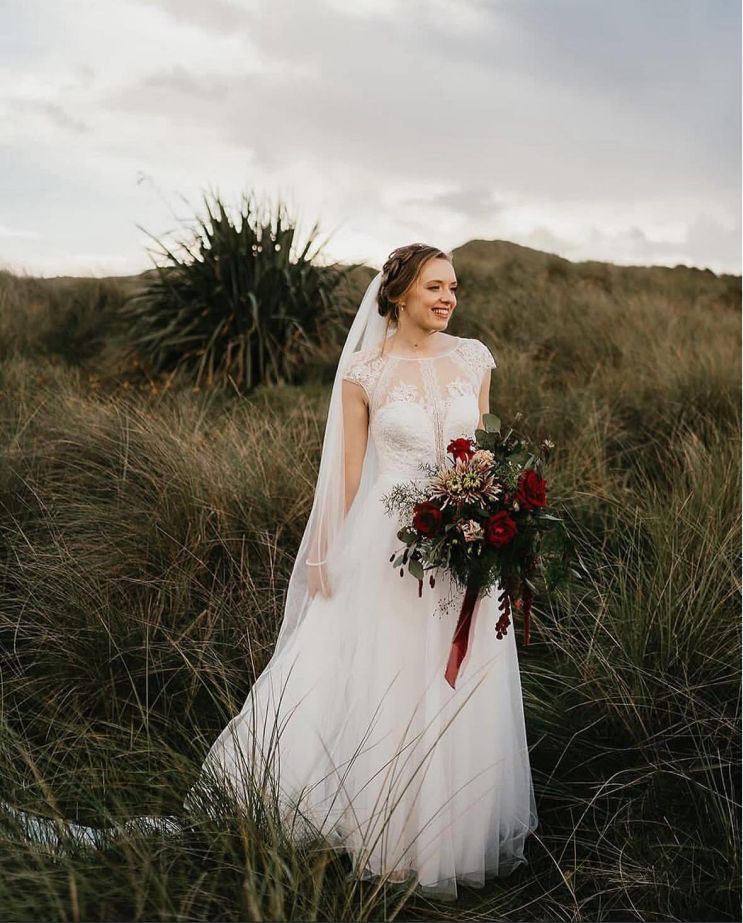 Bride in field with bouquet