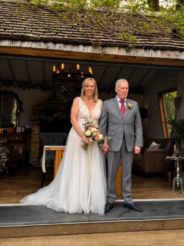 Bride with bouquet standing with her partner at their wedding venue