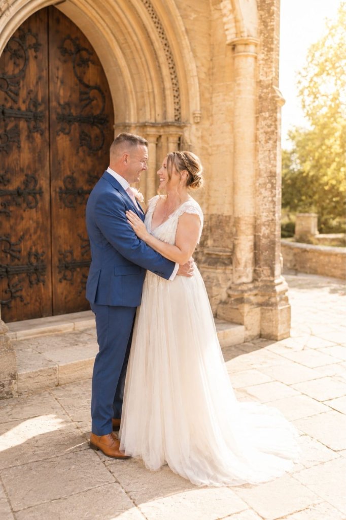 Bride and groom embracing by an ornate wooden door
