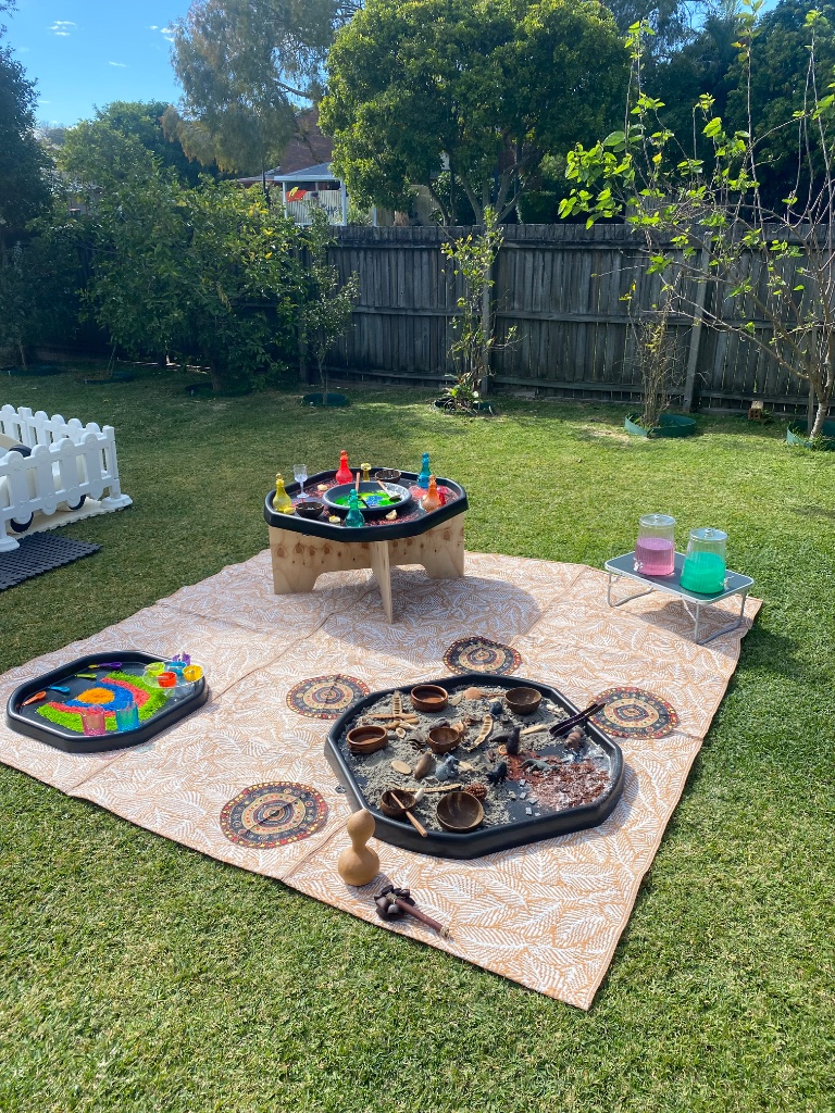 Full outdoor sensory play setup with trays and mats
