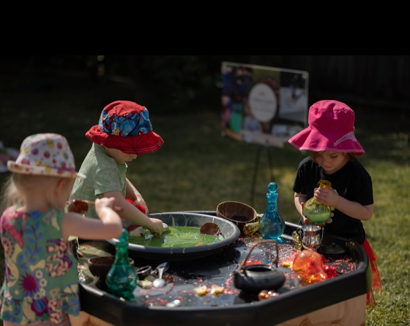 Three children exploring potions at a sensory station