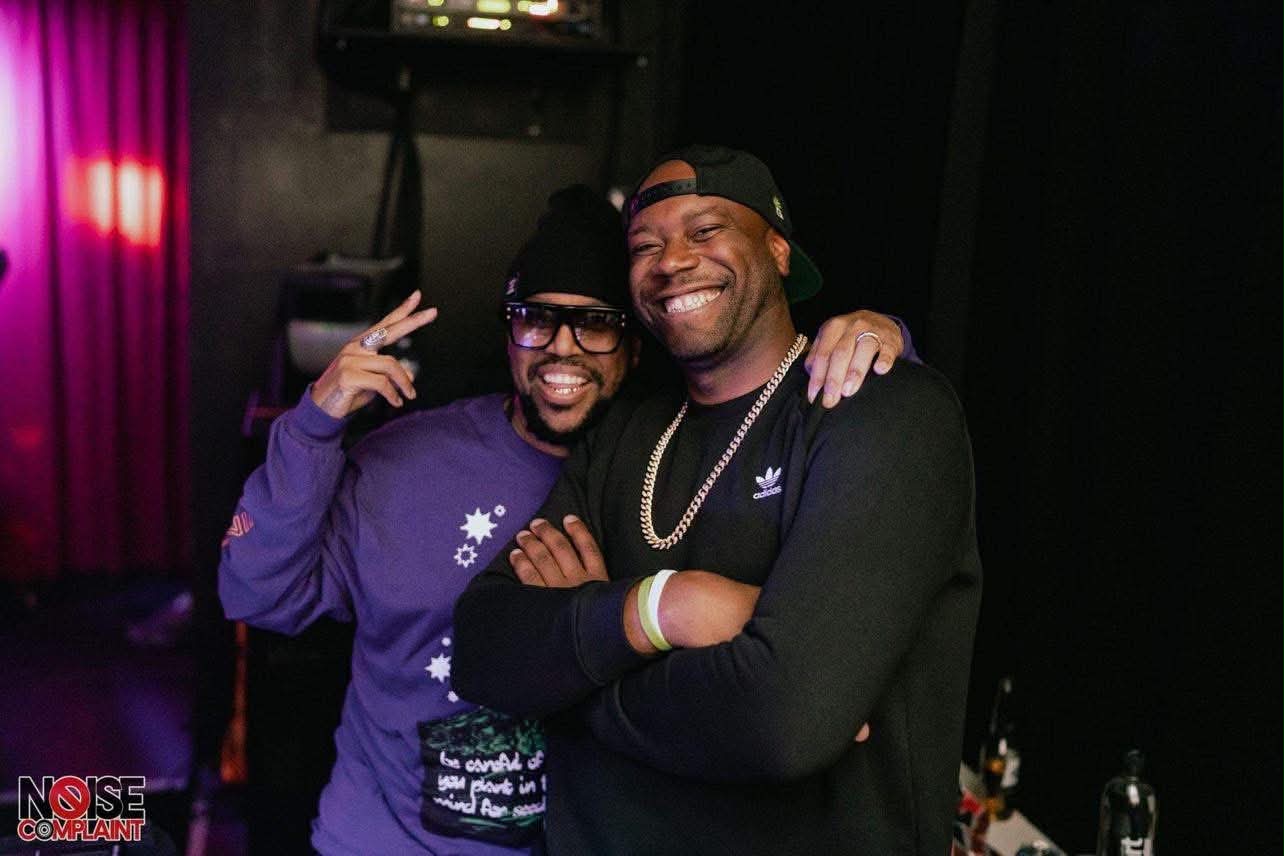 Josh Houston with a friend at a nightlife event, with a NOISE COMPLAINT credit visible in the corner.