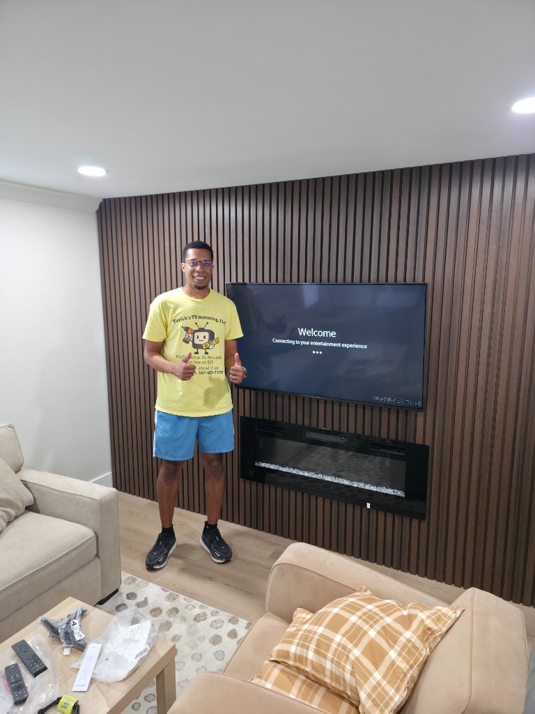 Large TV on slat wall above fireplace