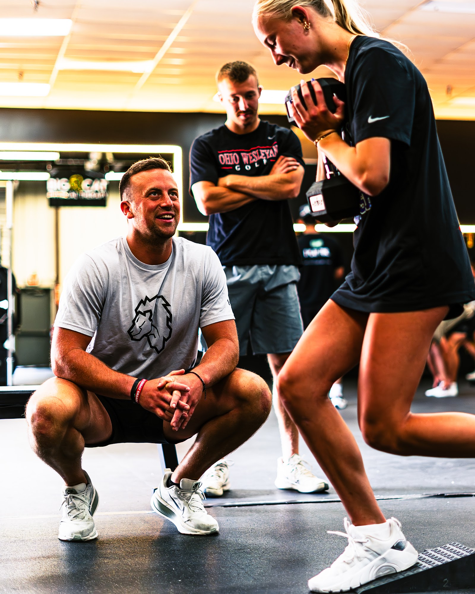 Coach guiding an athlete through a loaded step-up