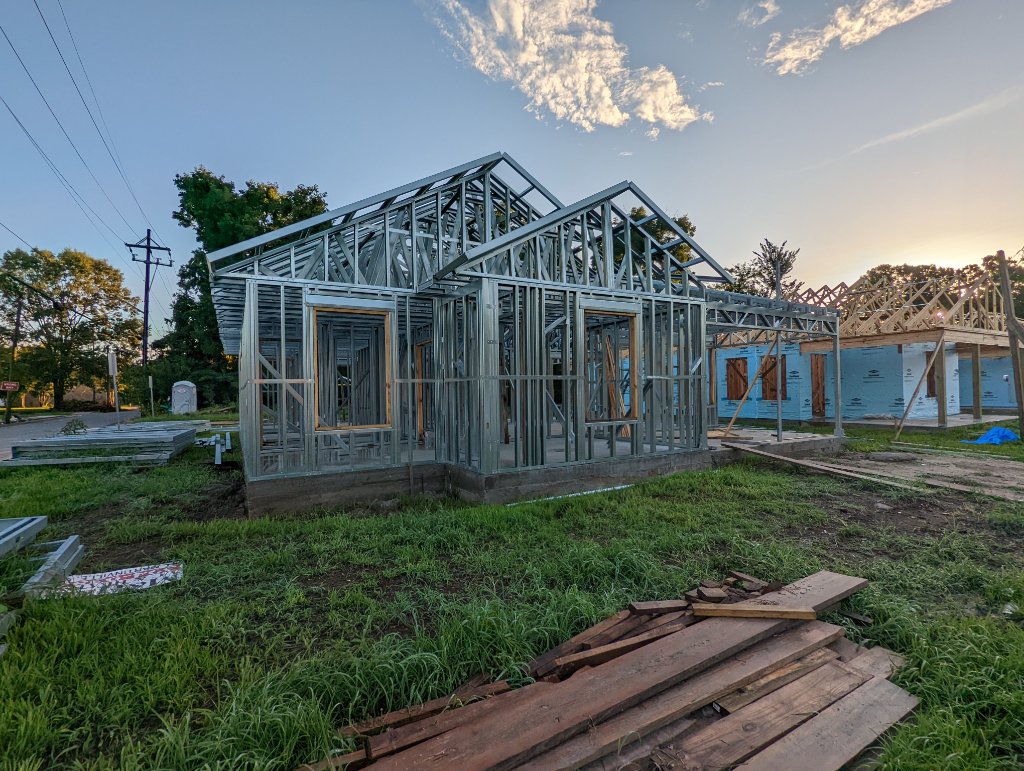 CFS single-family frame erected at dusk — walls and roof trusses complete