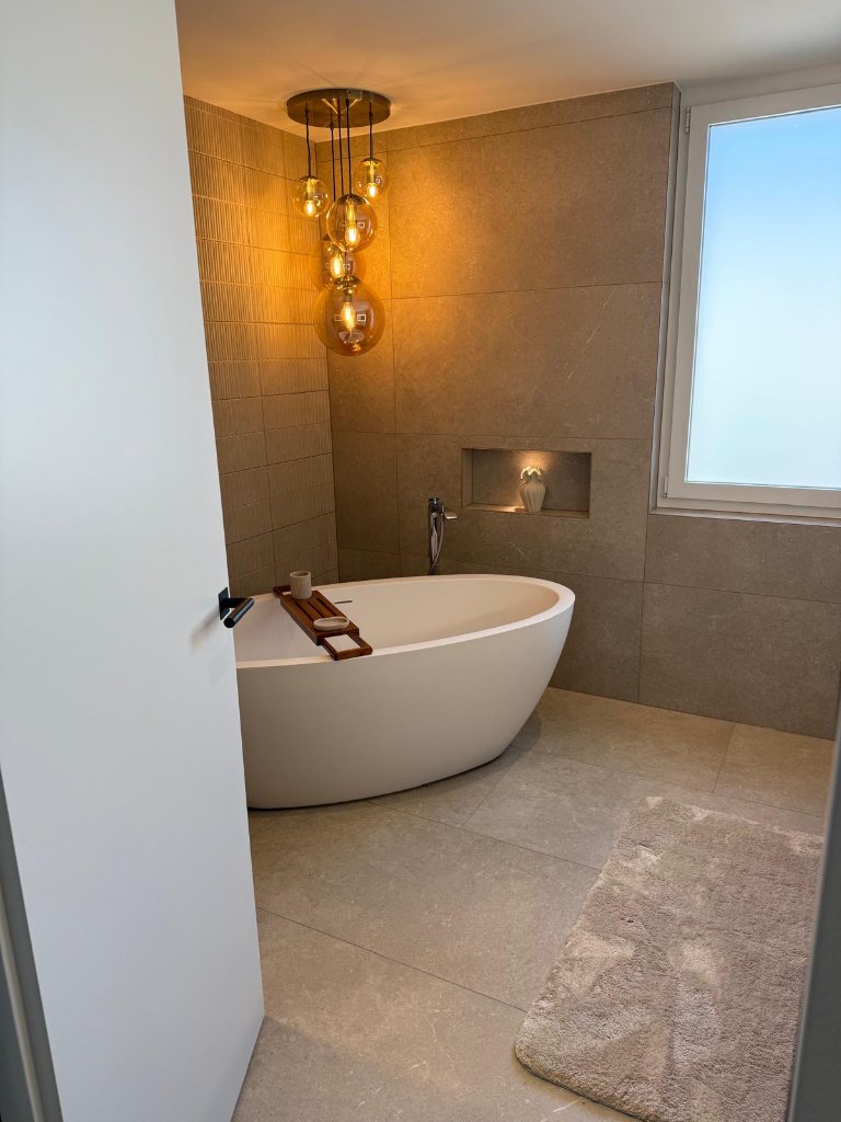 Freistehende Badewanne mit Natursteinboden