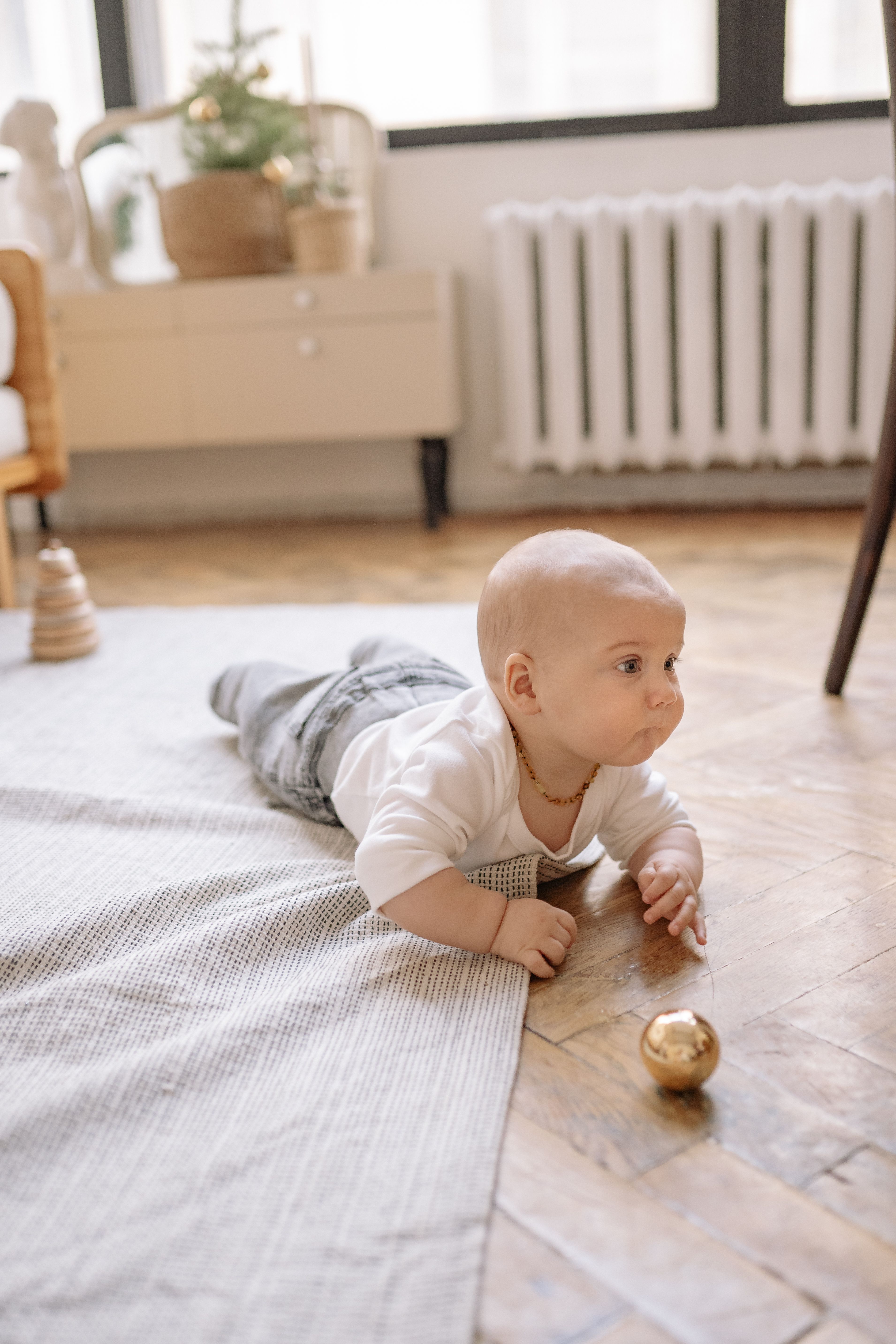 Floor play on a firm surface lets a baby practice lifting and pushing against gravity.