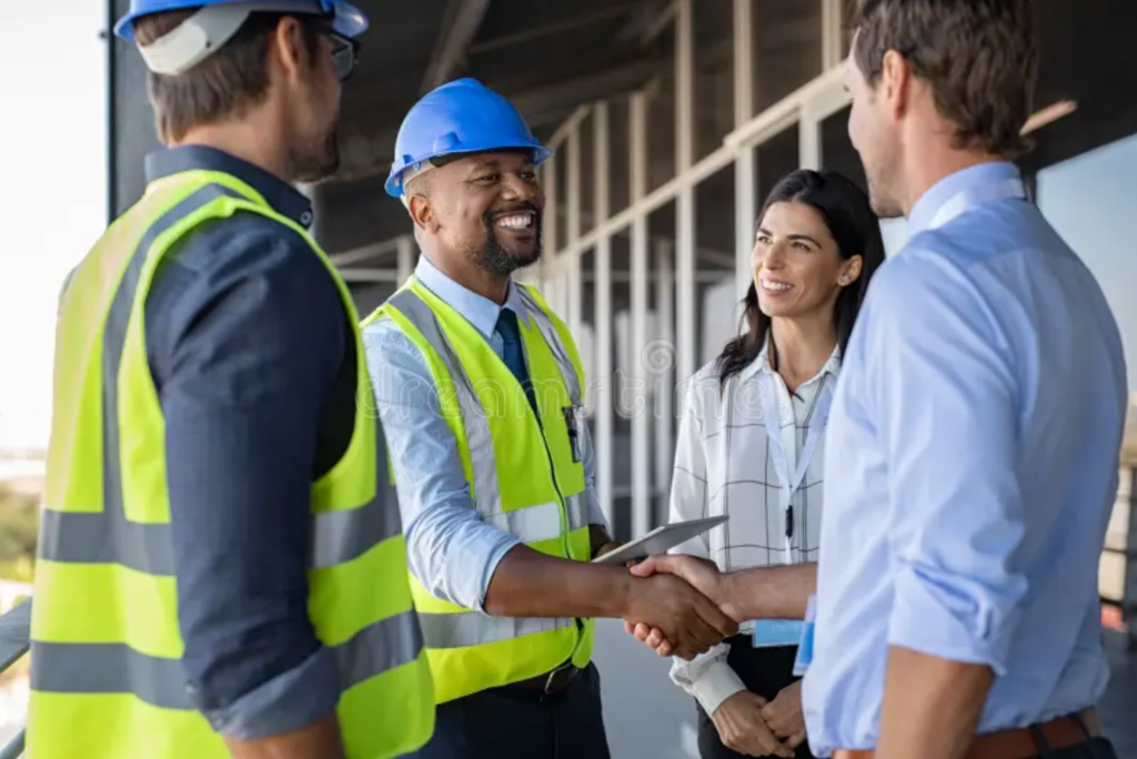 Construction workers shaking hands on site