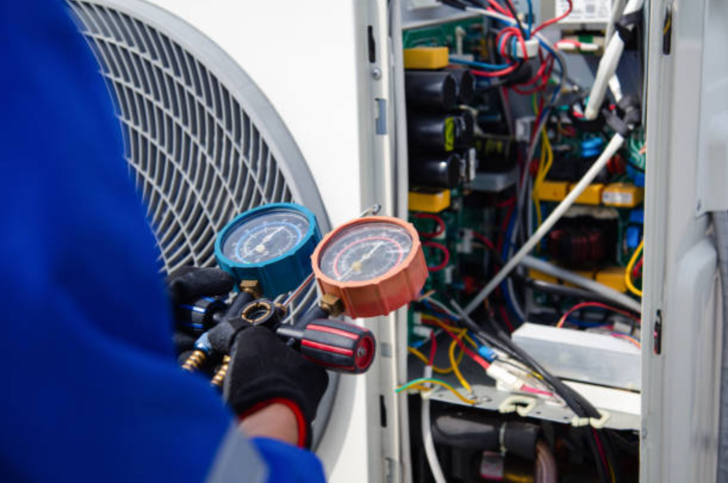 HVAC technician checking refrigerant gauges on unit